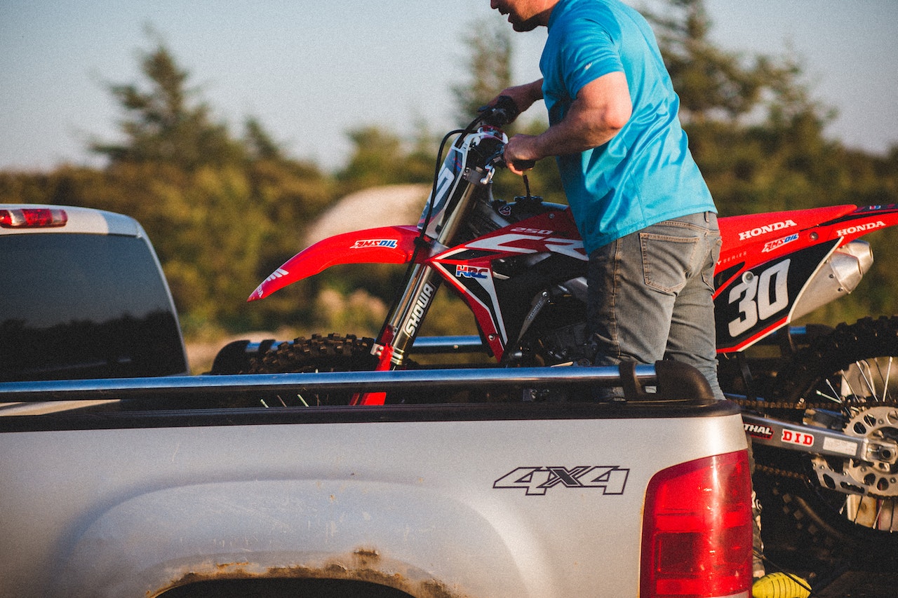 Man Packing Motorcycle on Pick-up Truck | Veteran Car Donations