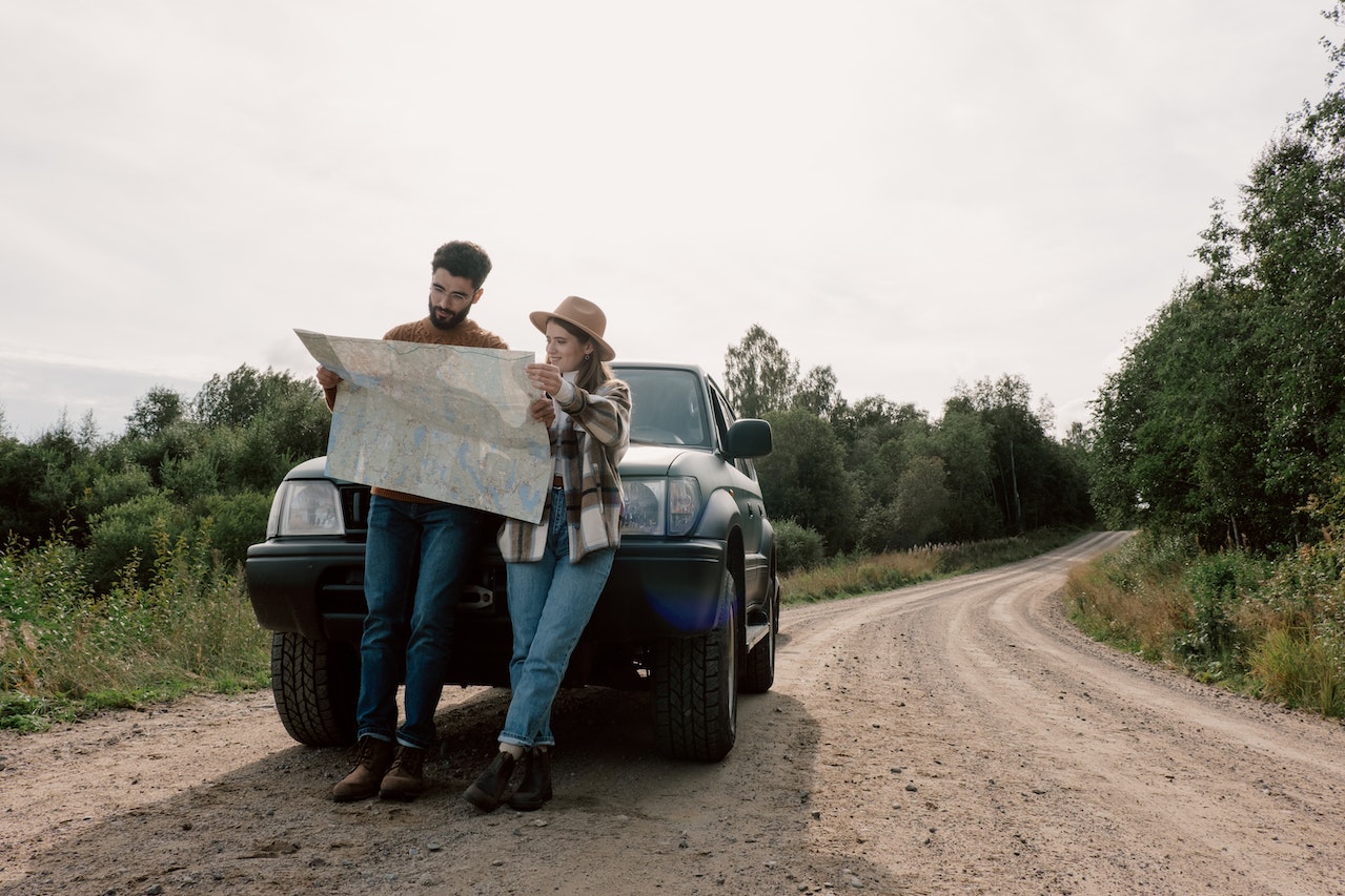 A Couple on a Road Trip Looking at a Map | Veteran Car Donations
