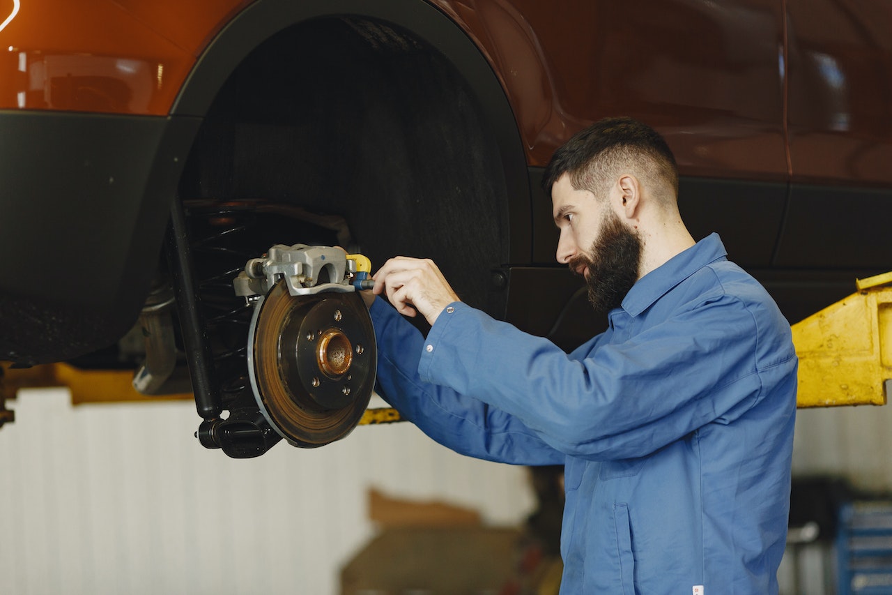 Man in Blue Uniform Fixing the Car's Brake System | Veteran Car Donations