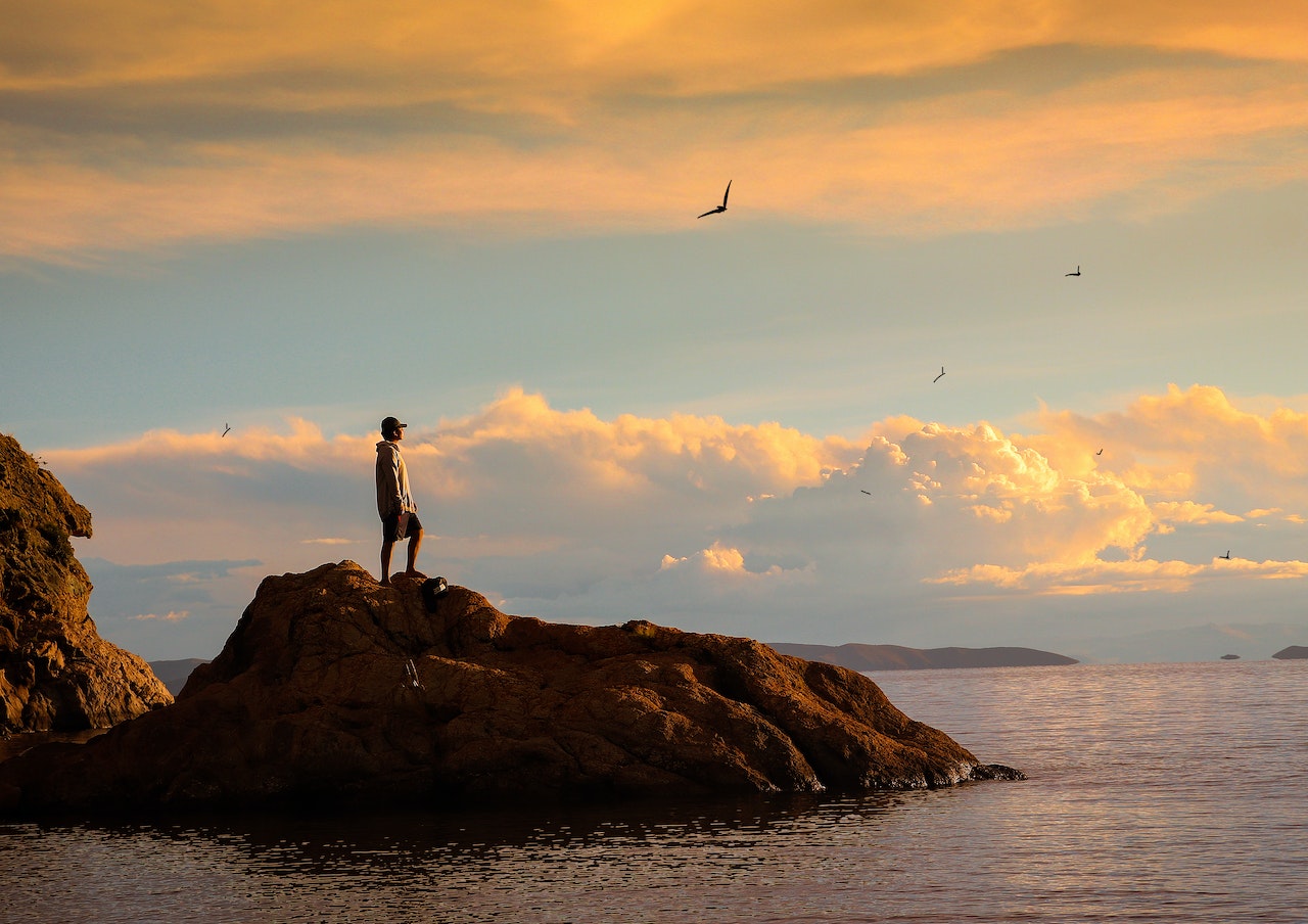 Silhouette of Person Standing on Rock during Sunset | Veteran Car Donations
