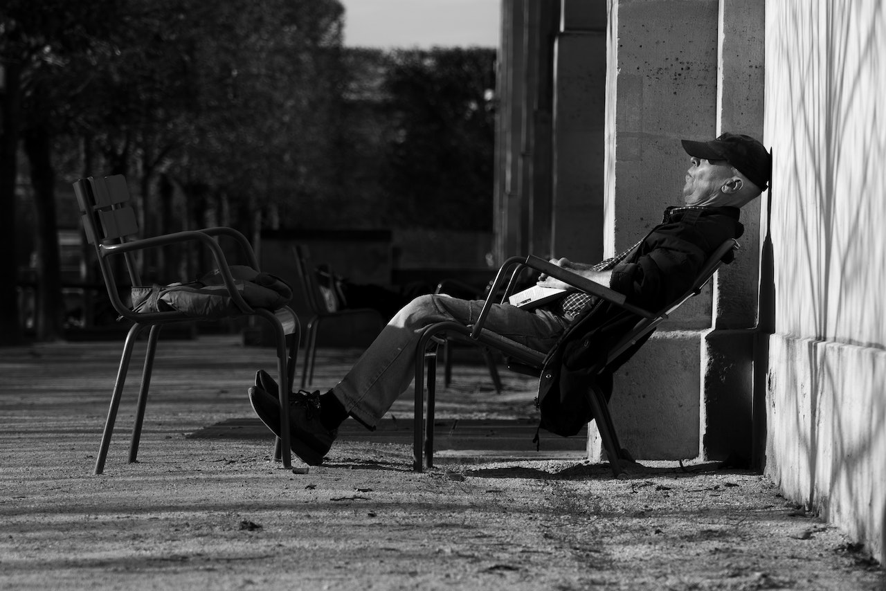 Grayscale Photo of a Man Sitting on a Chair | Veteran Car Donations
