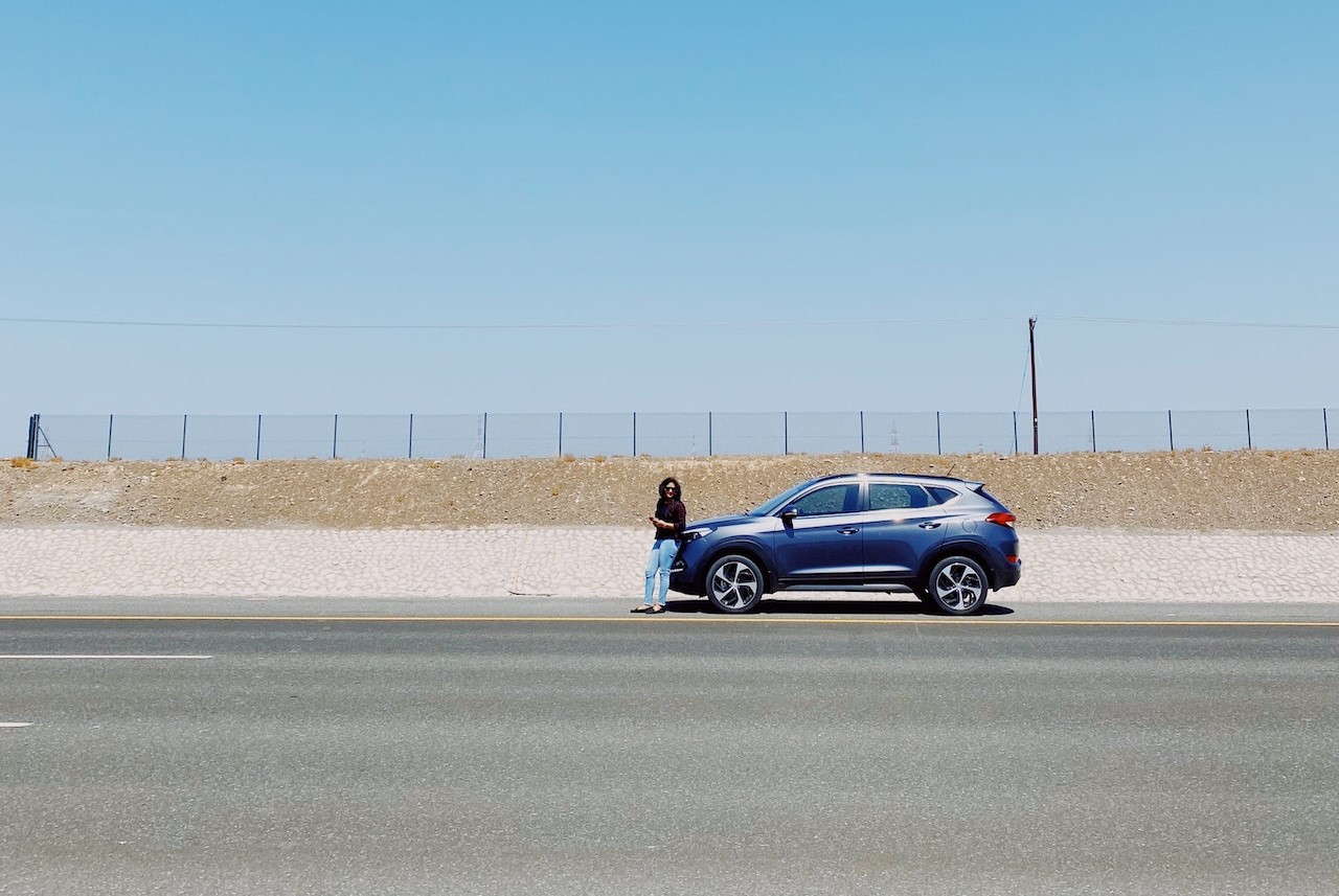 A Person Leaning on a Blue Car | Veteran Car Donations