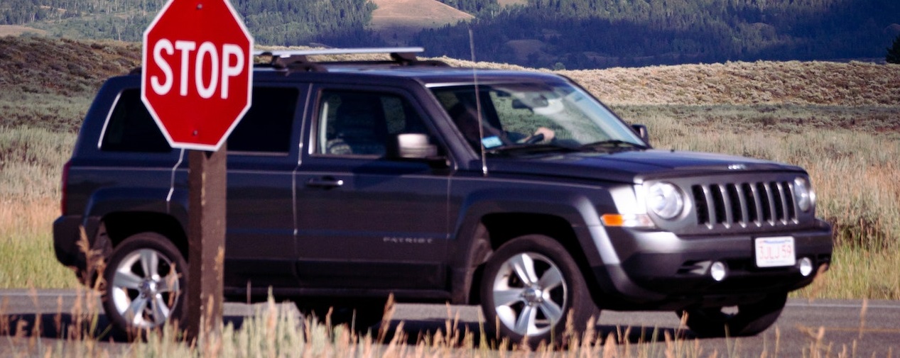 Black SUV parked on STOP sign | Veteran Car Donations