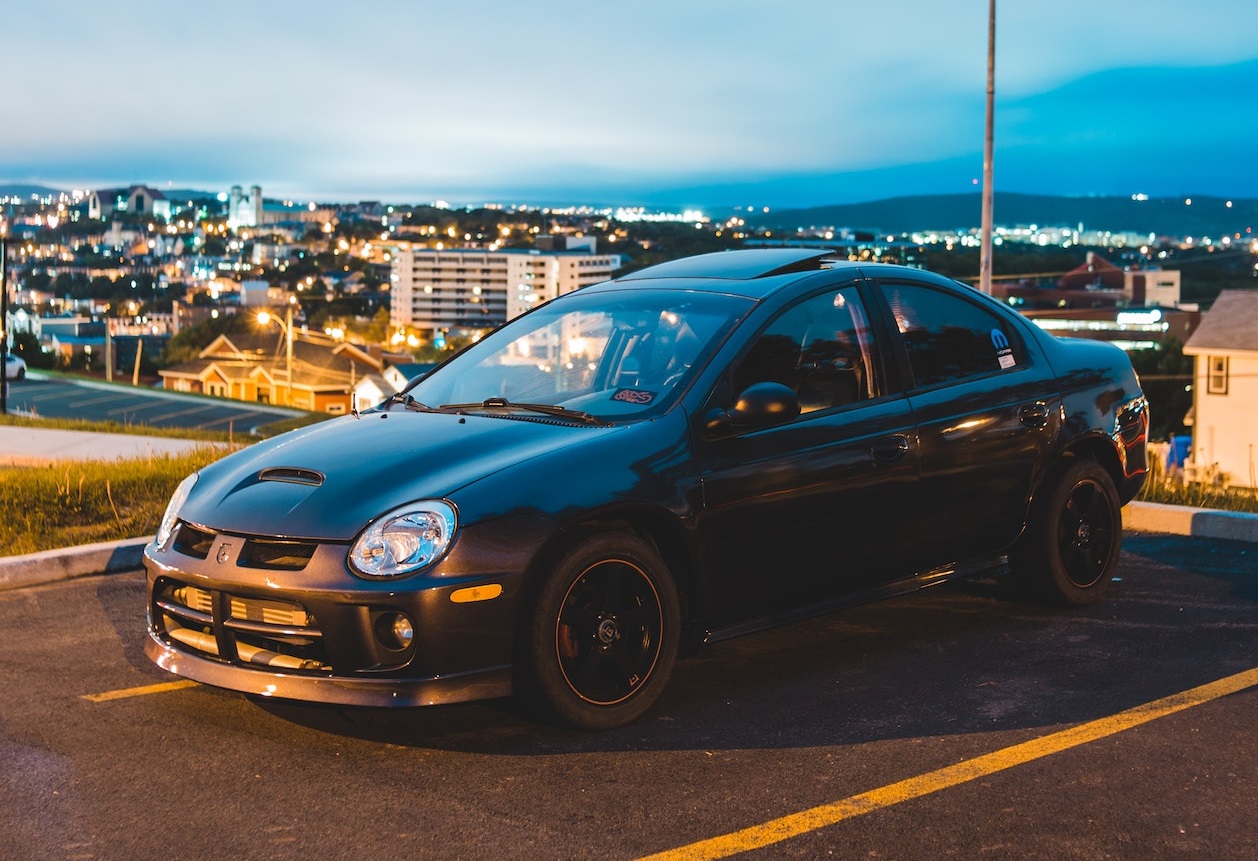 Black Sedan parked on empty parking lot | Veteran Car Donations