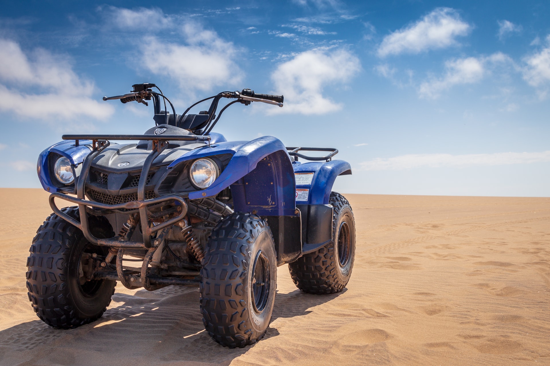 Blue ATV parked on a sand | Veteran Car Donations