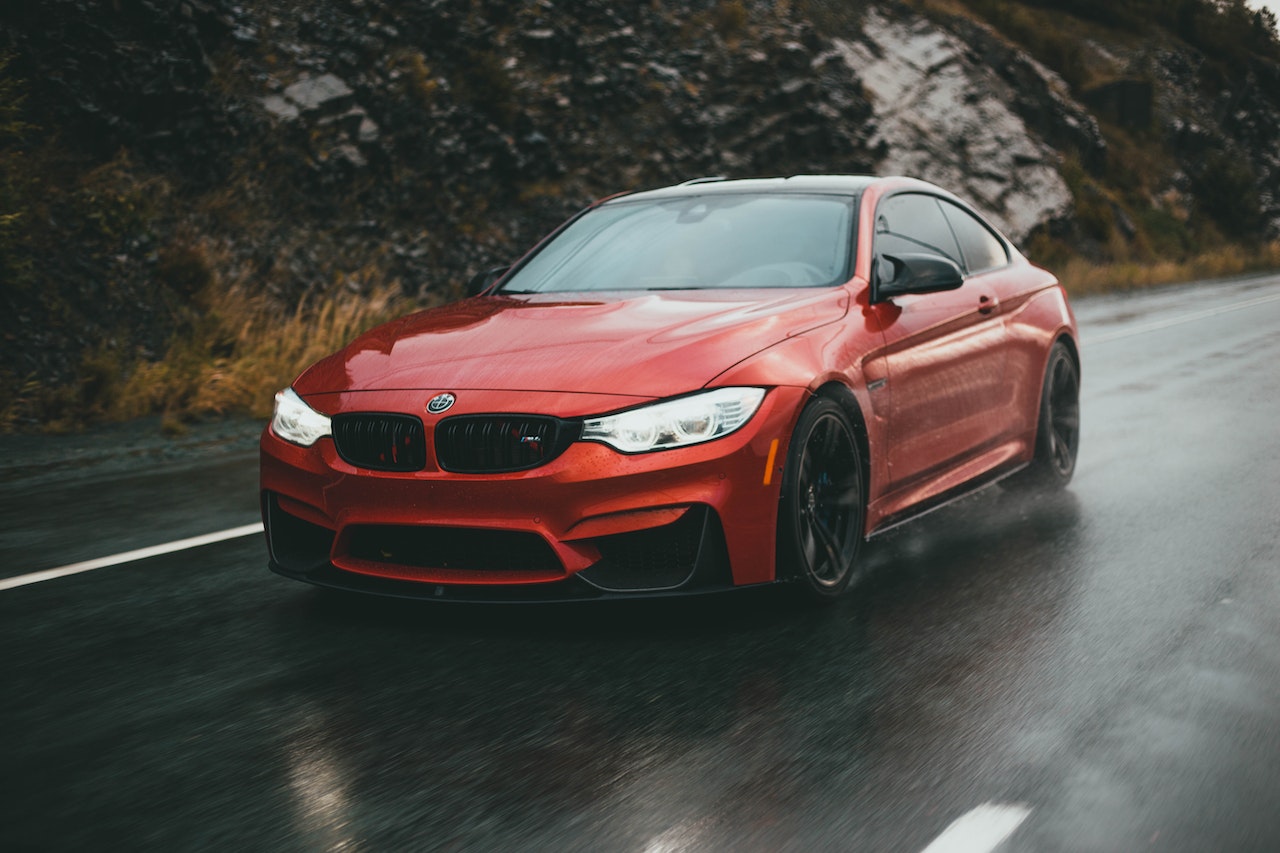Driving a Red BMW Sportscar on the Wet Road | Veteran Car Donations