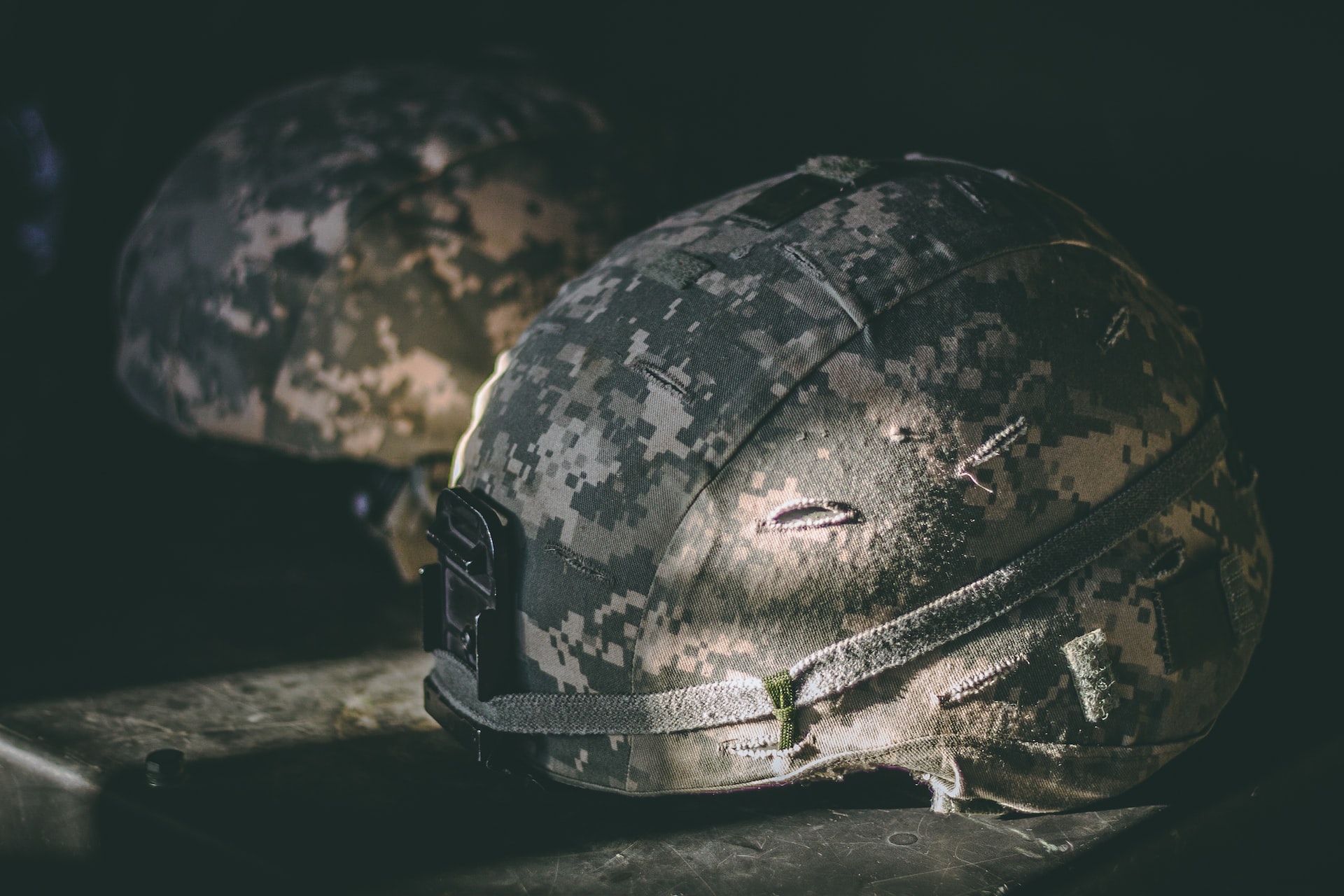 Gray and Brown Camouflage Nutshell Helmet on Table | Veteran Car Donations
