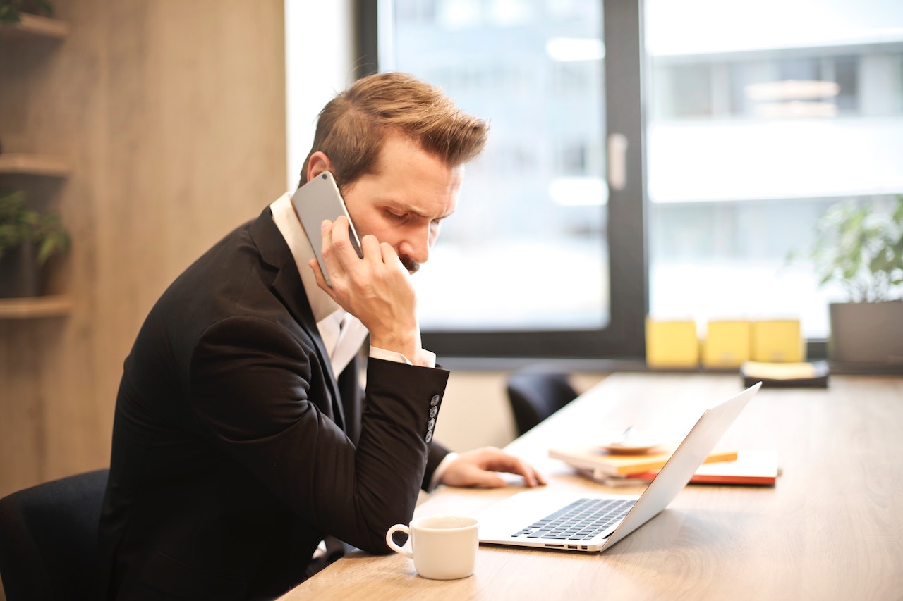 Man Having a Phone Call In-front of a Laptop | Veteran Car Donations