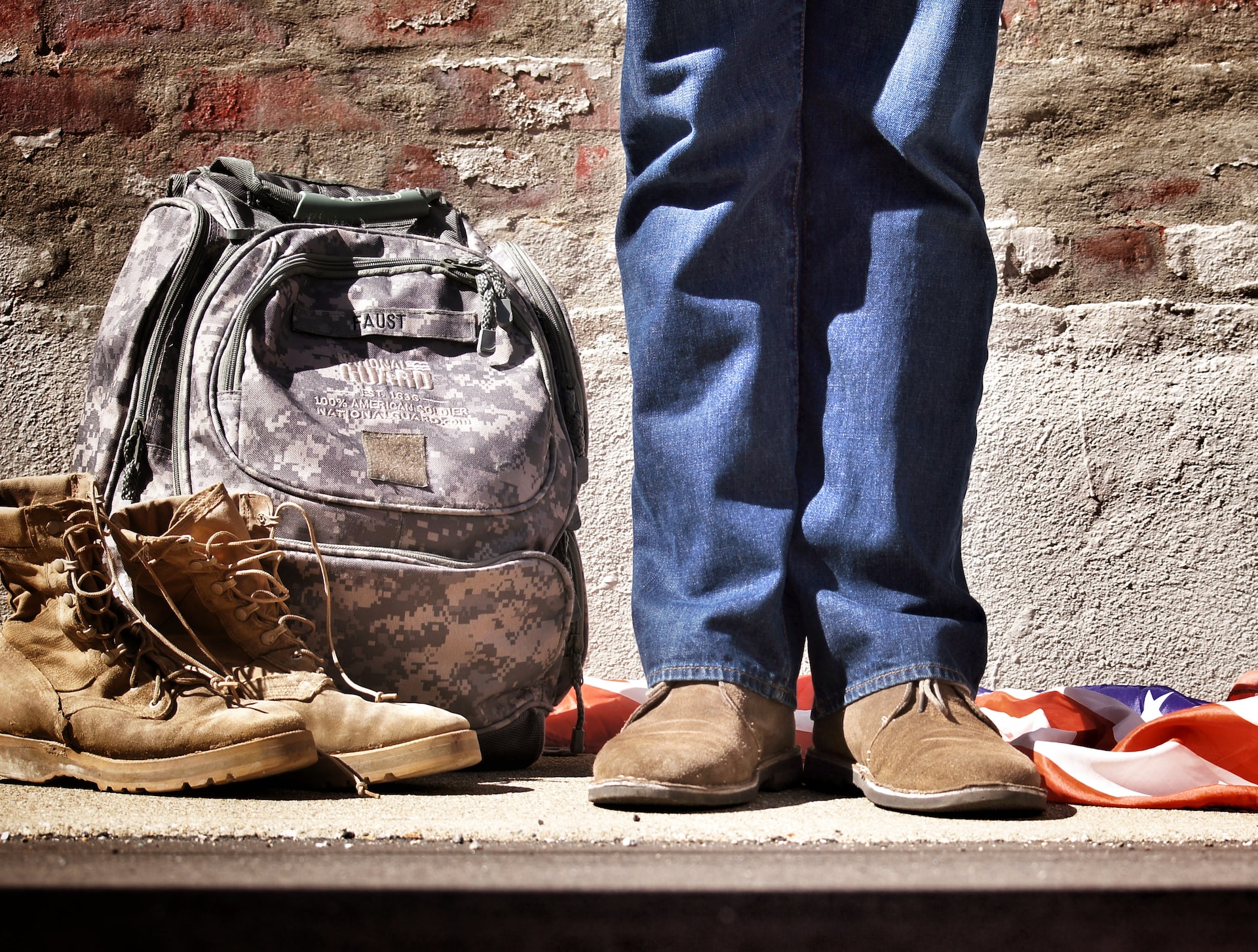 Minimalist Photo of a Person Standing Near Backpack and Boots | Veteran Car Donations
