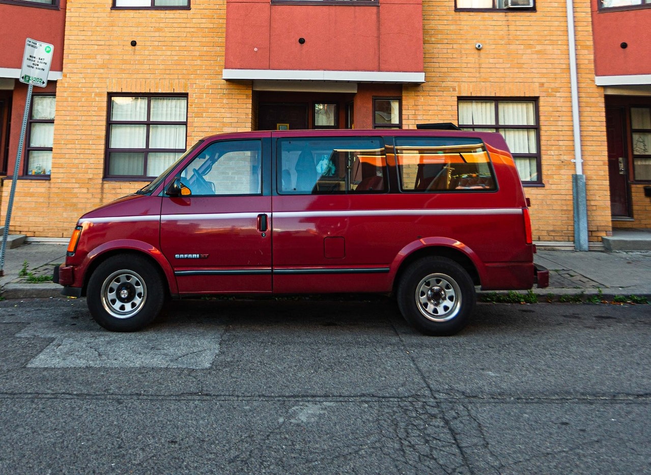 Red Van Parked Near a Concrete Building | Veteran Car Donations