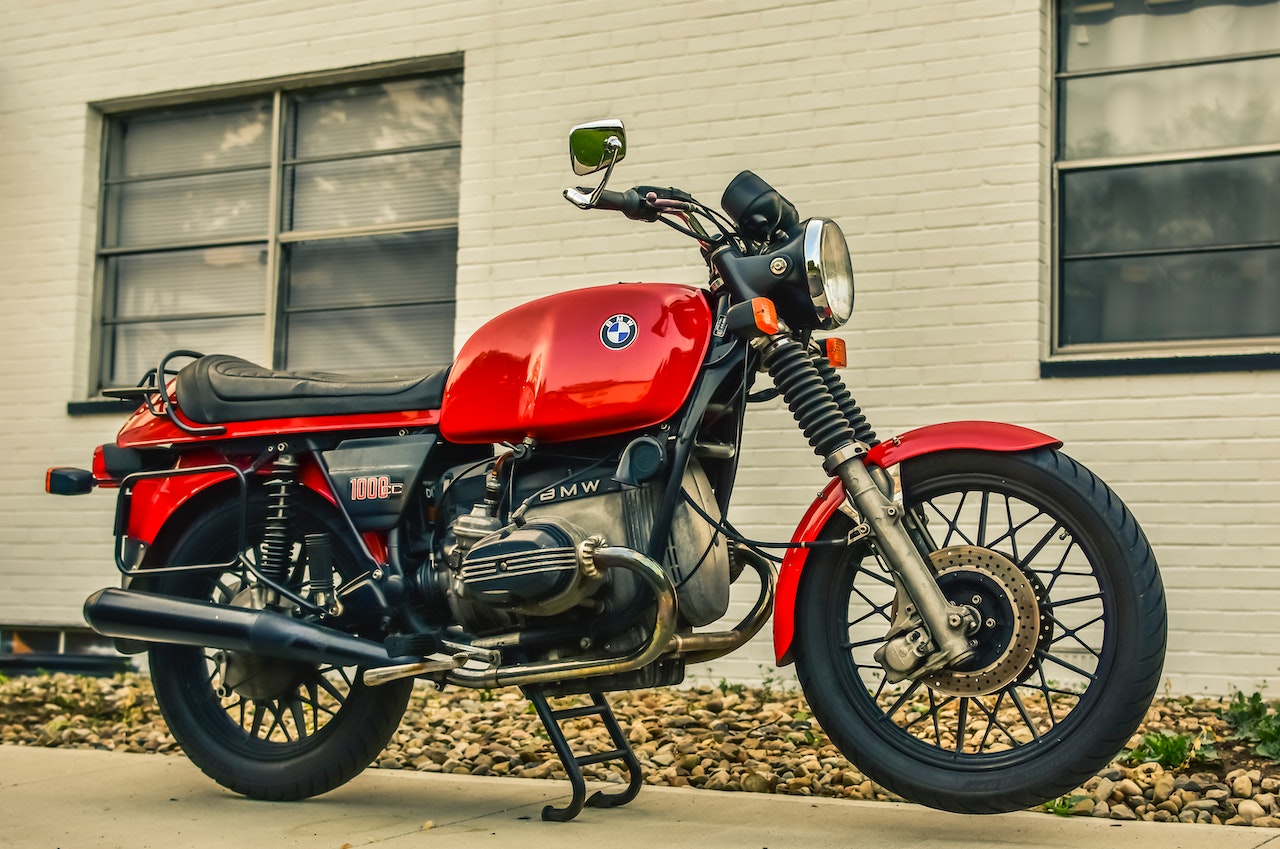 Red and Black Motorcycle Parked Beside the Building | Veteran Car Donations