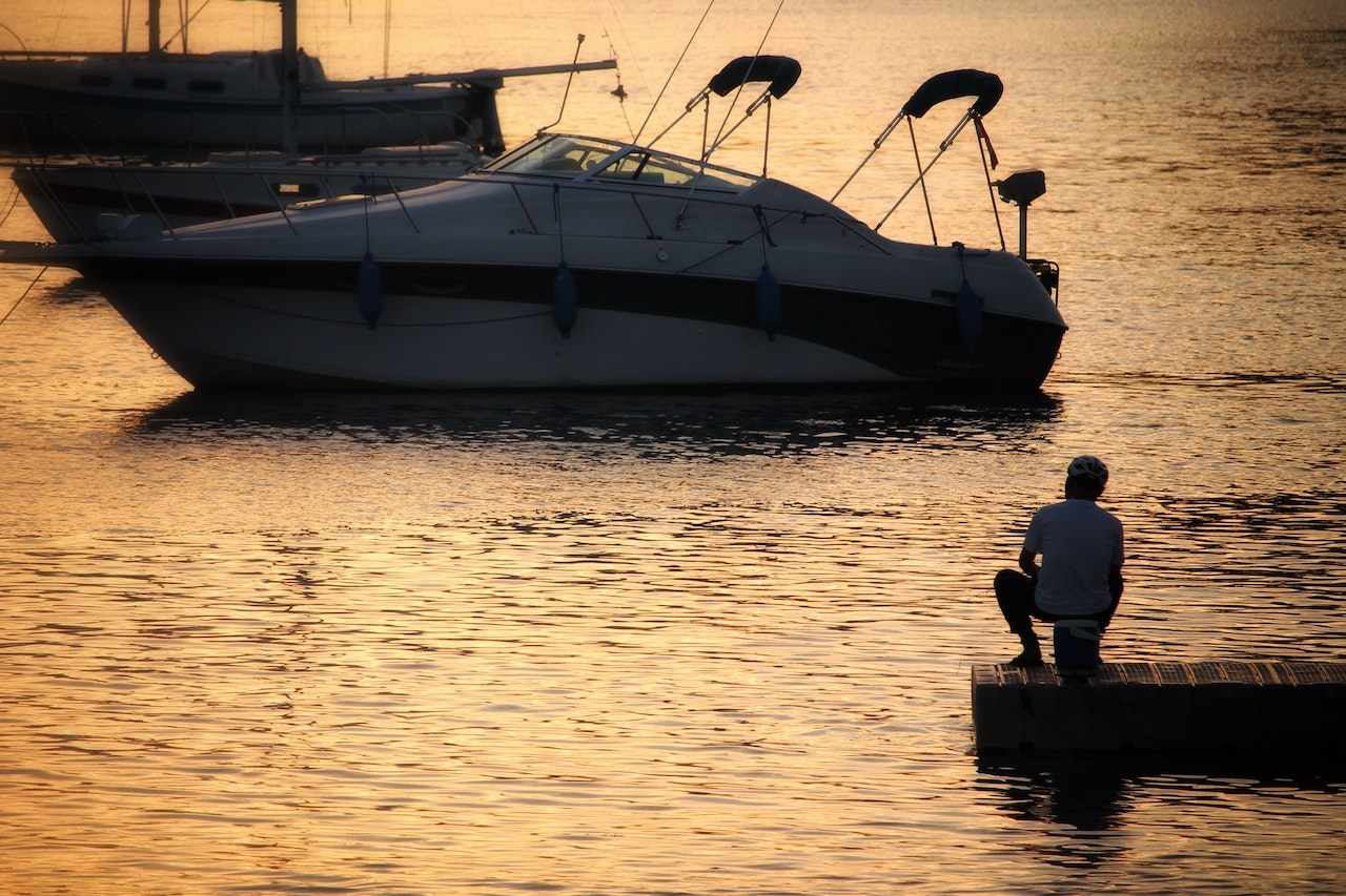 Silhouette of a boat with a man on dock | Veteran Car Donations