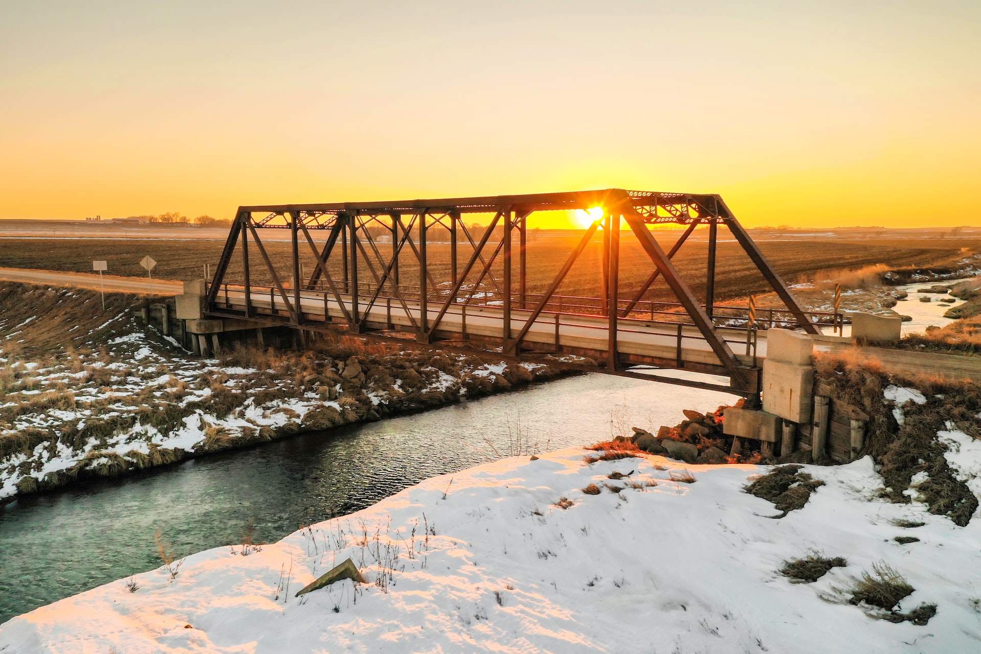 Steel bridge on a country road during golden hour in rural Iowa | Veteran Car Donations