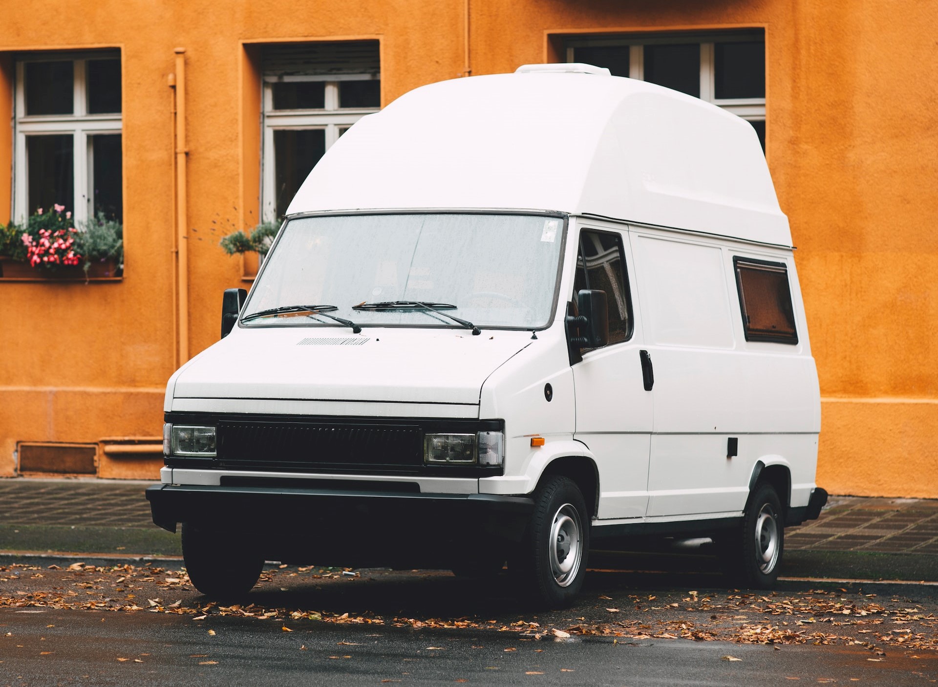 White Van Near the Yellow Wall Building | Veteran Car Donations