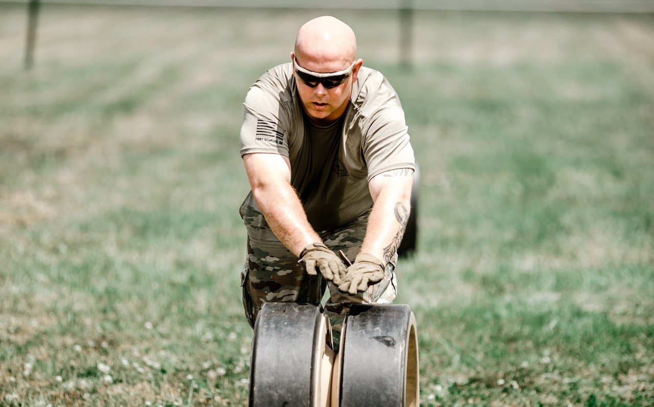 A Soldier Rolling a Wheel on Grass | Veteran Car Donations
