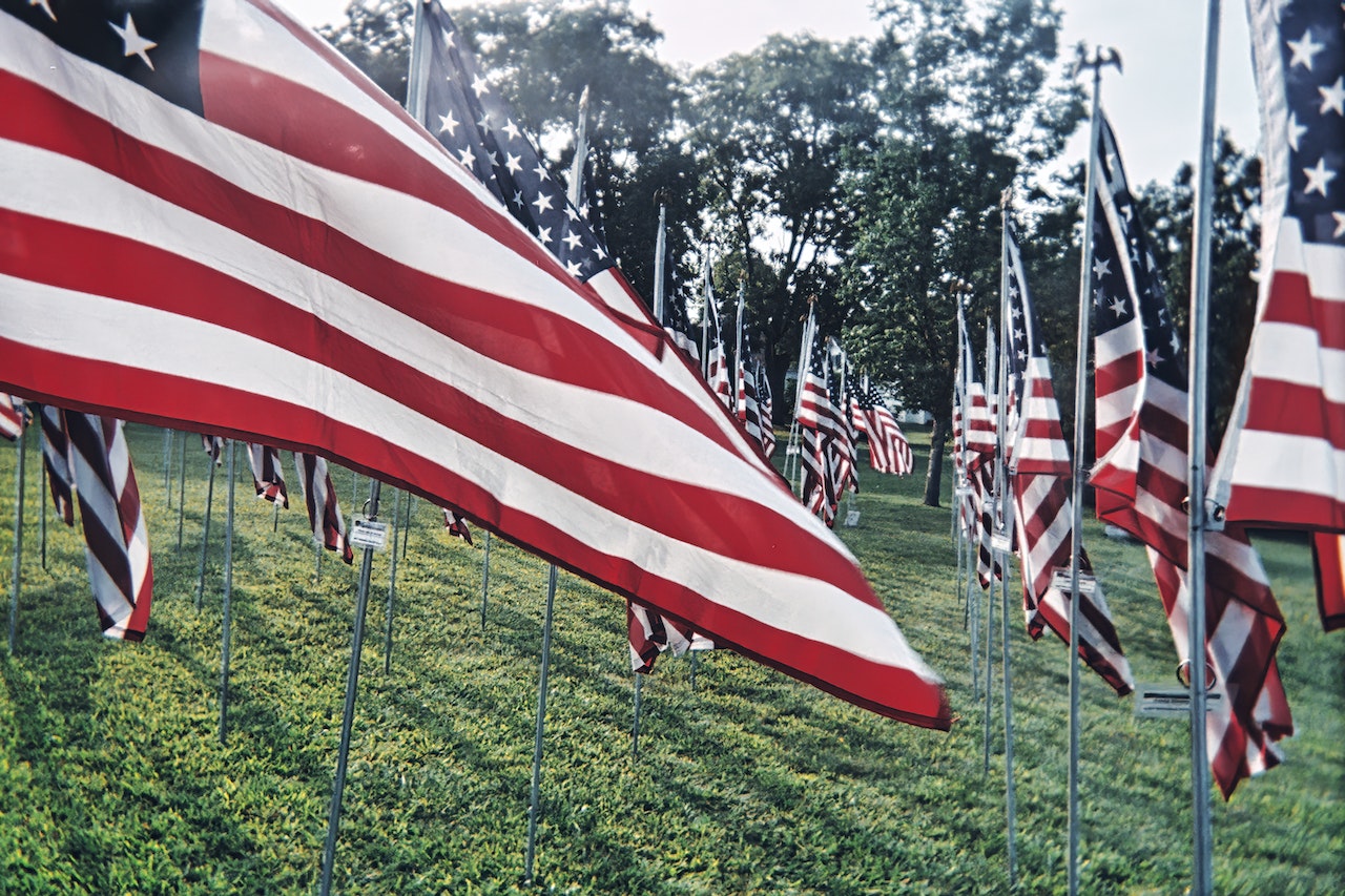 US Flags on Green Grass Field | Veteran Car Donations

