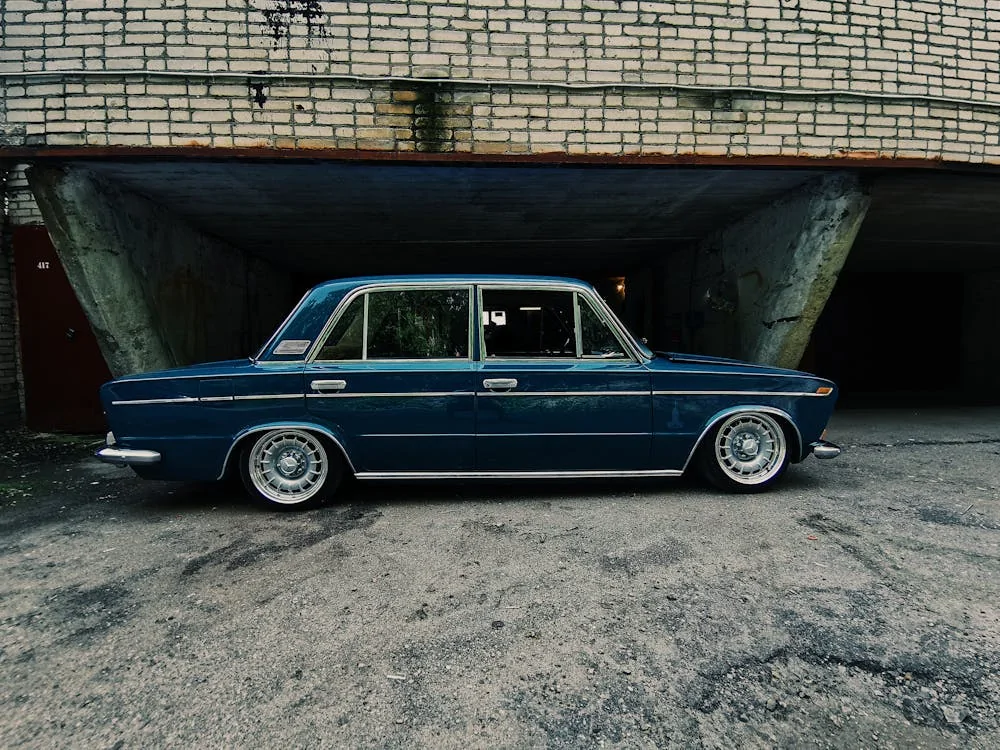 A Blue Vintage Car Parked Beside the Abandoned Building