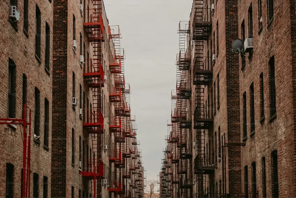 A Couple of People Walking Down a Street Next to Tall Buildings in Bronx, New York