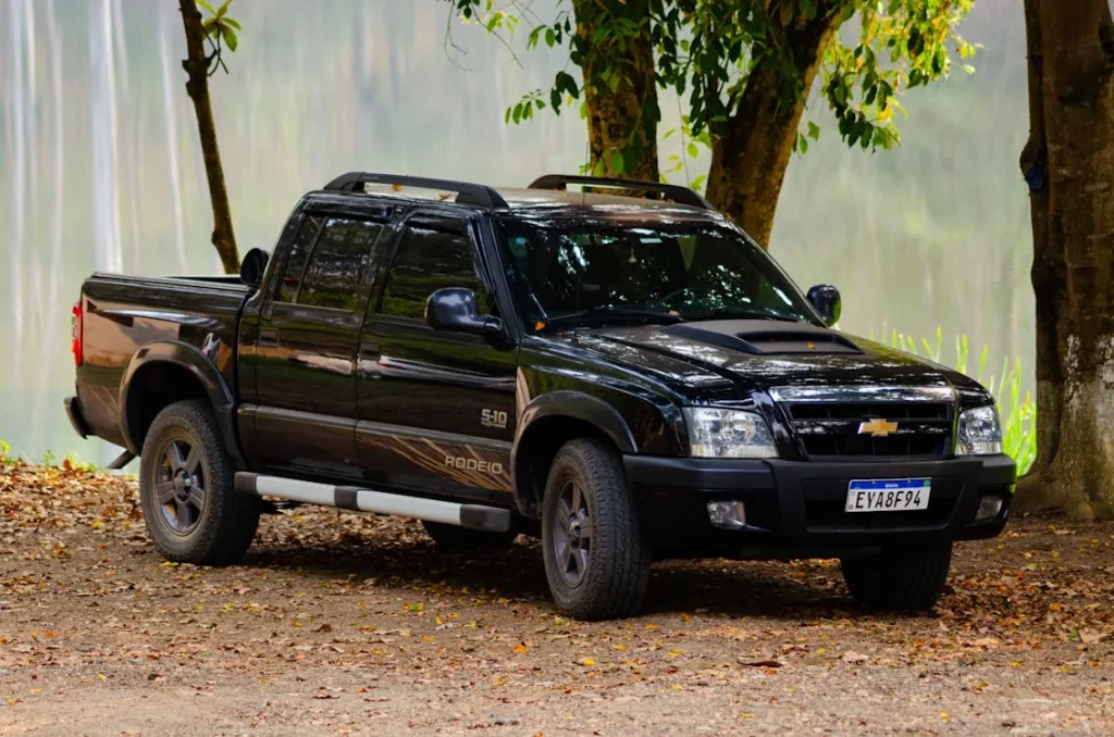 A black truck parked in front of a lake