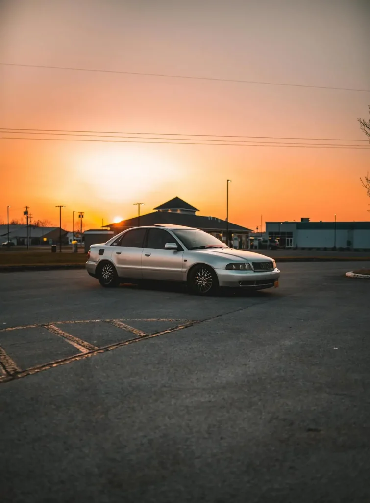 Silver sedan car parked on the road during sunset