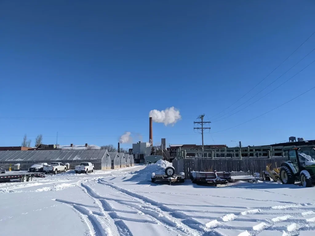 Snow-covered road with a factory in the background in Fargo, North Dakota