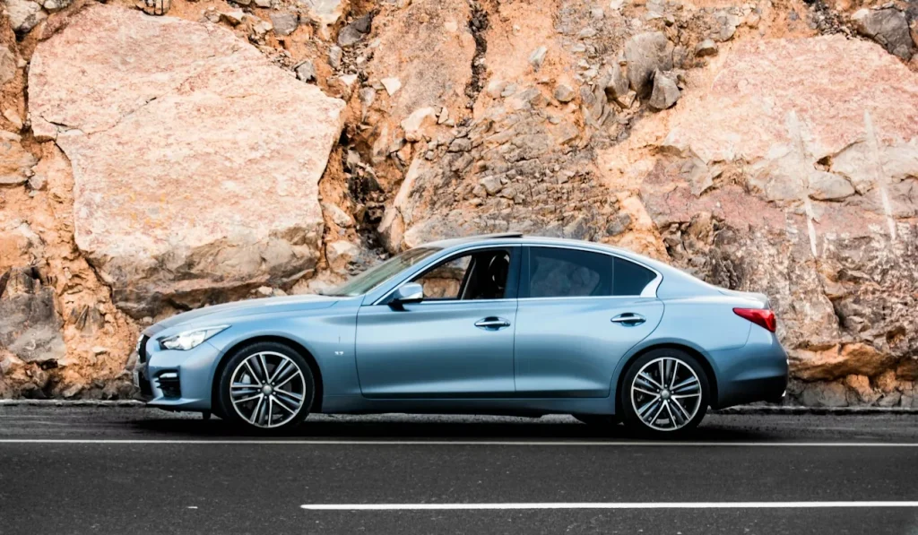 Blue sedan parked on a road