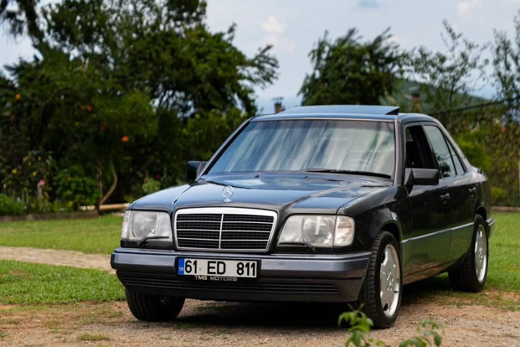 Classic black sedan parked outdoors in a lush green summer setting