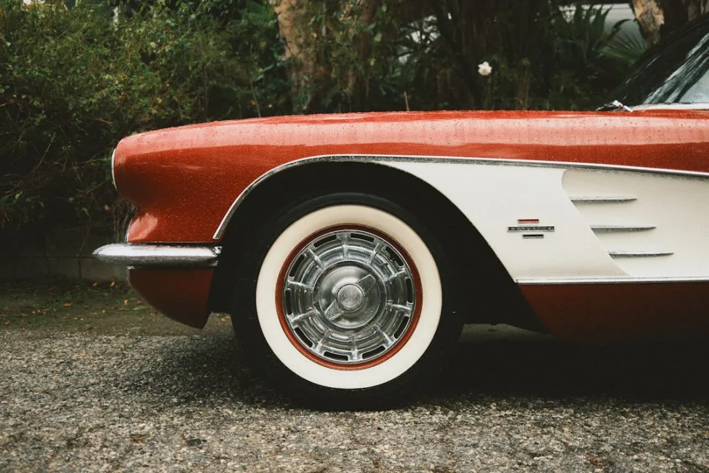 Close-up of a classic red vintage car highlighting chrome details and headlight design