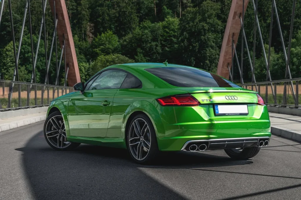 Green Audi sports car parked in the middle of the road