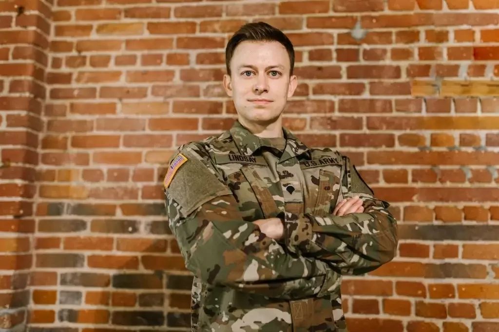 Photo of a soldier standing in front of a brick wall