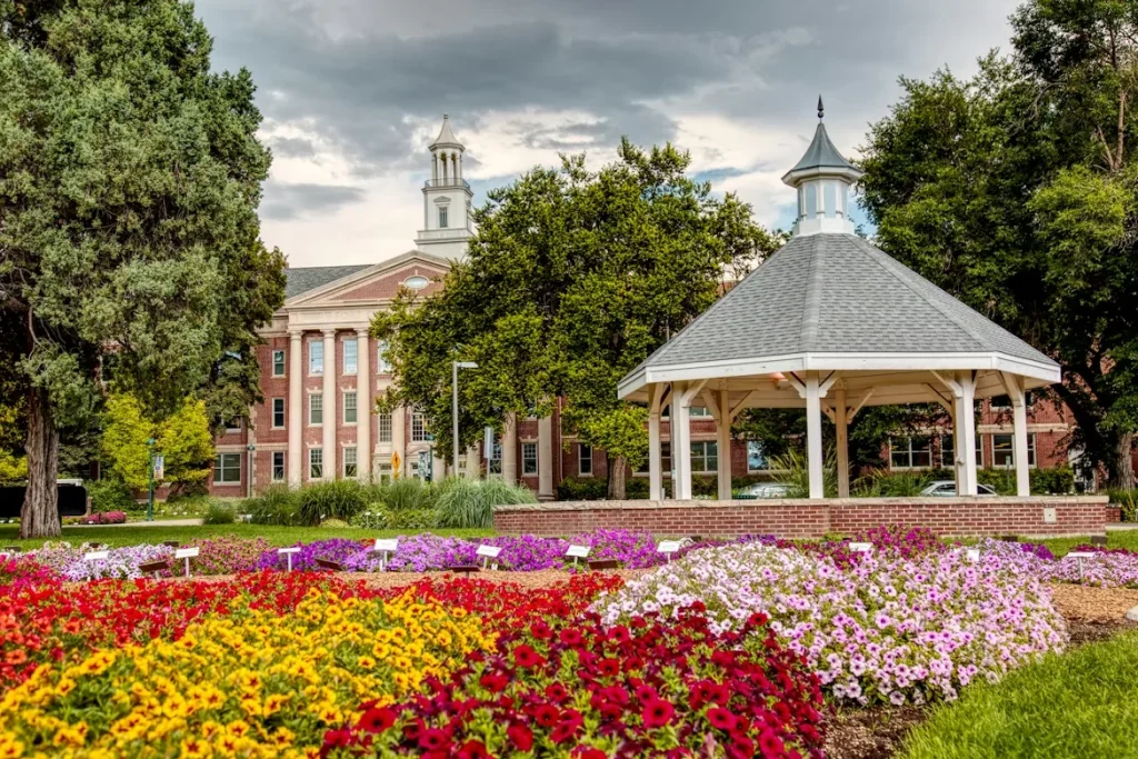 Colorful flower field surrounding a gazebo and house at CSU Flower Beds in Fort Collins, CO