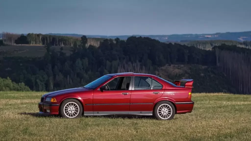 Red car parked on green grass field