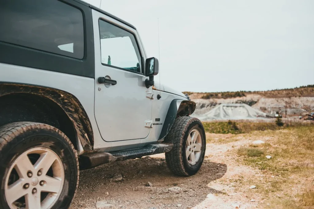 White Wrangler jeep parked on an off-road area
