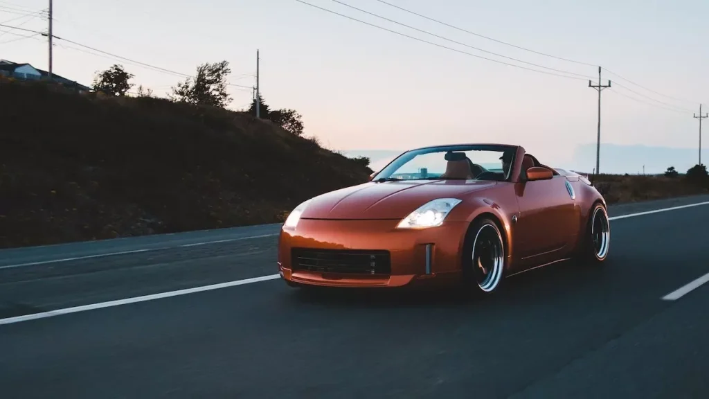 Stylish cabriolet with silver wheels driving on highway