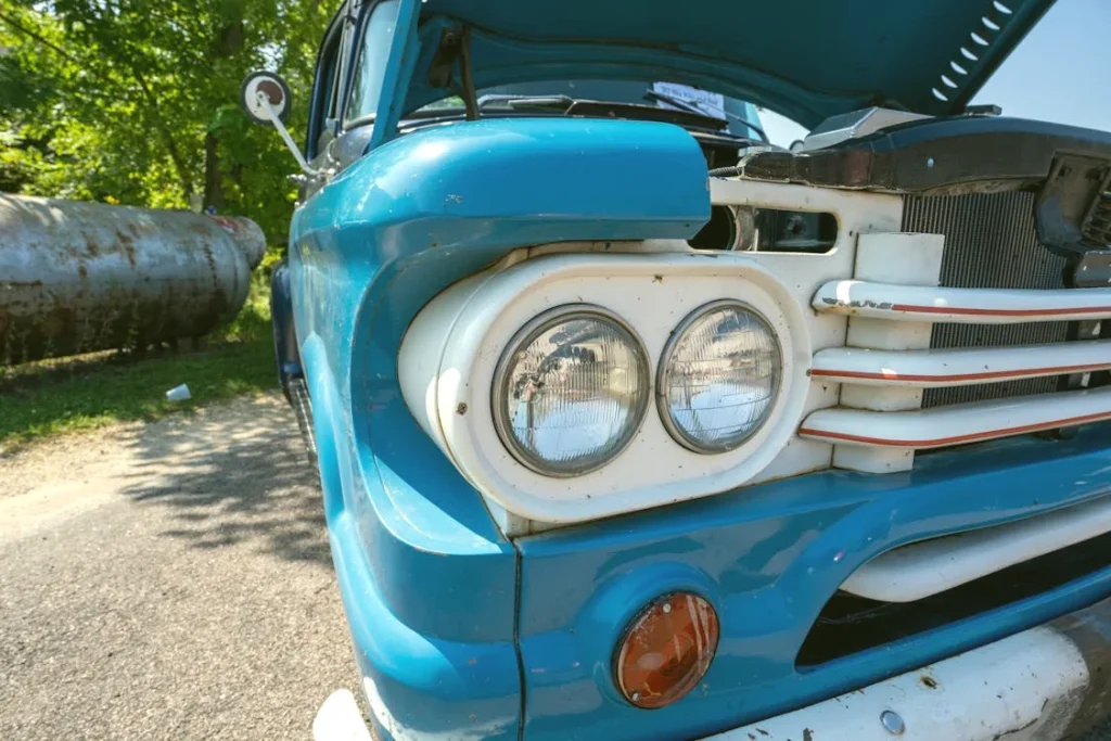 Vintage blue truck headlight close-up on a sunny day