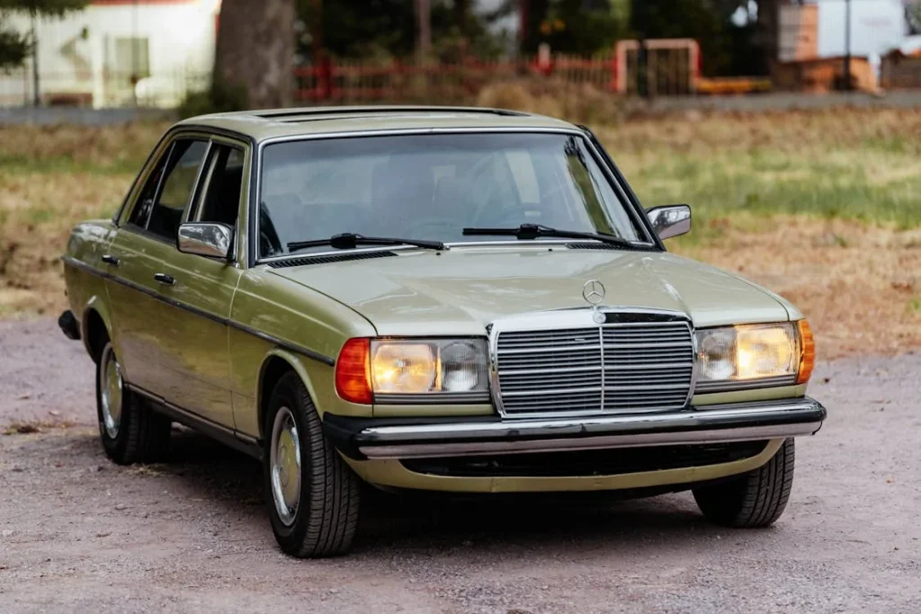 Vintage green sedan with headlights on outdoors