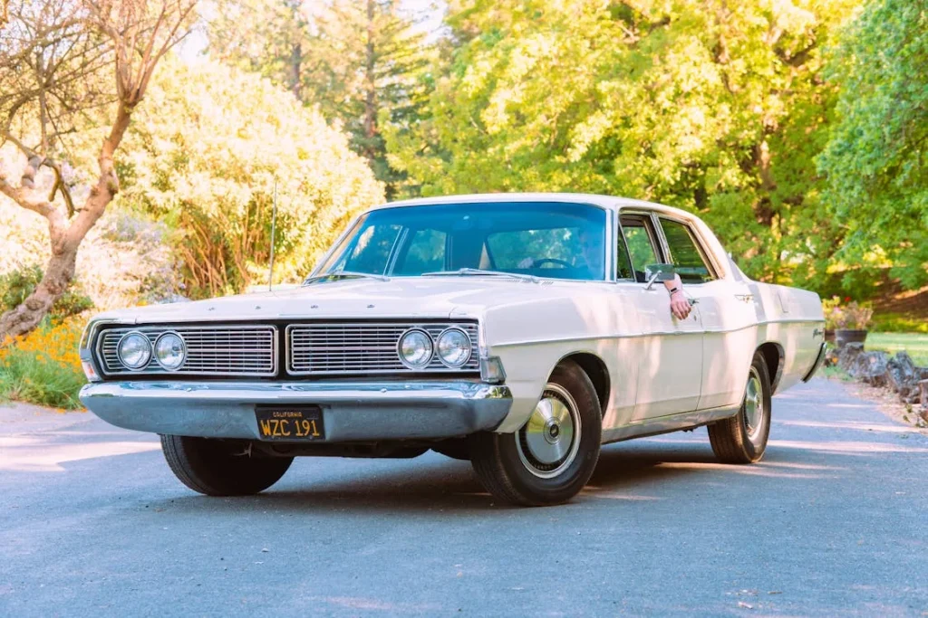 White vintage car in the middle of the road
