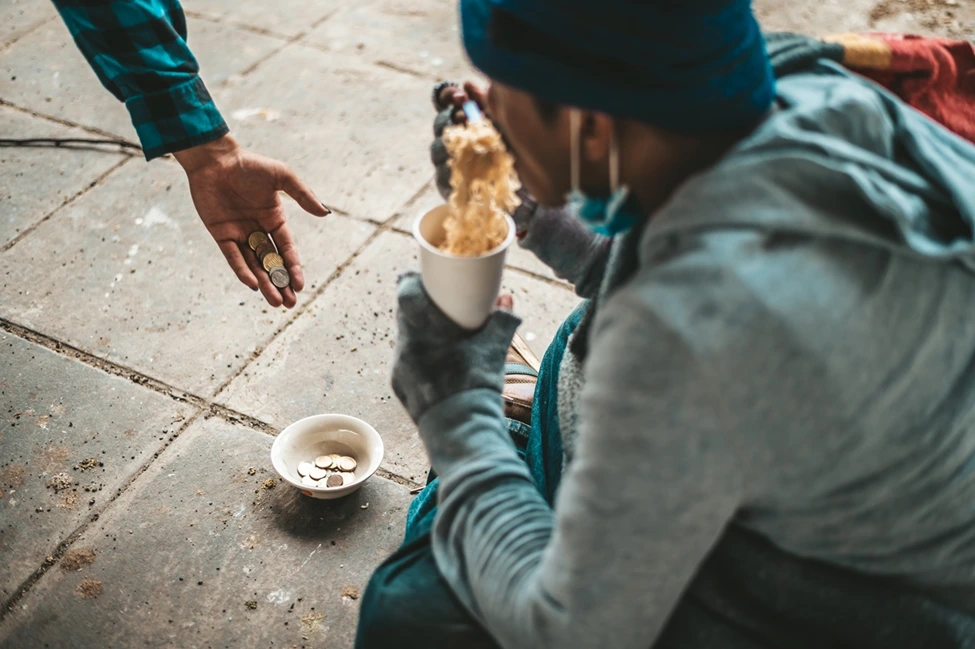 The beggars sat wrapped in cloths and eating noodles