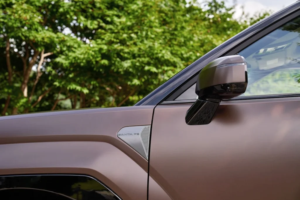 Photo of a brown car in front of a tree