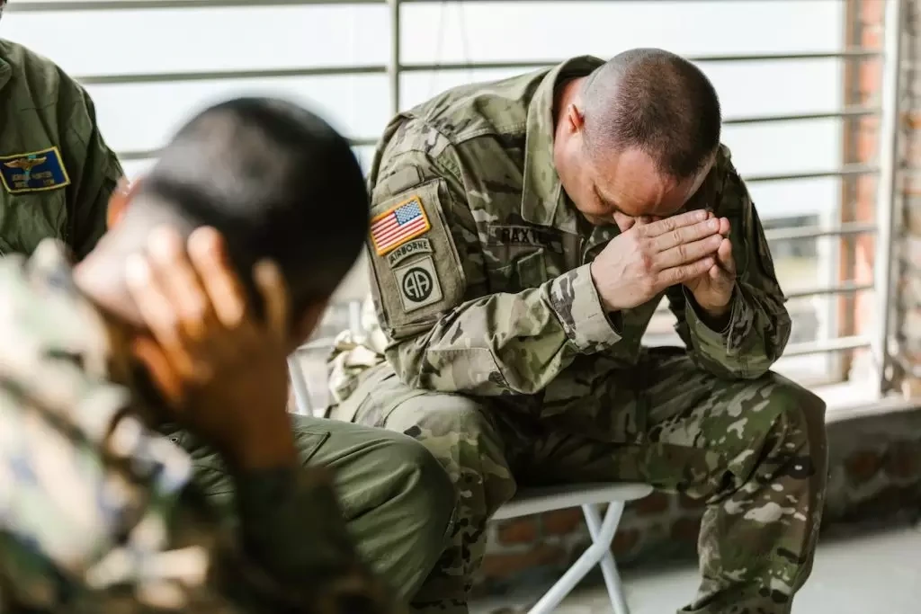 Man in uniform resting his head on his hands