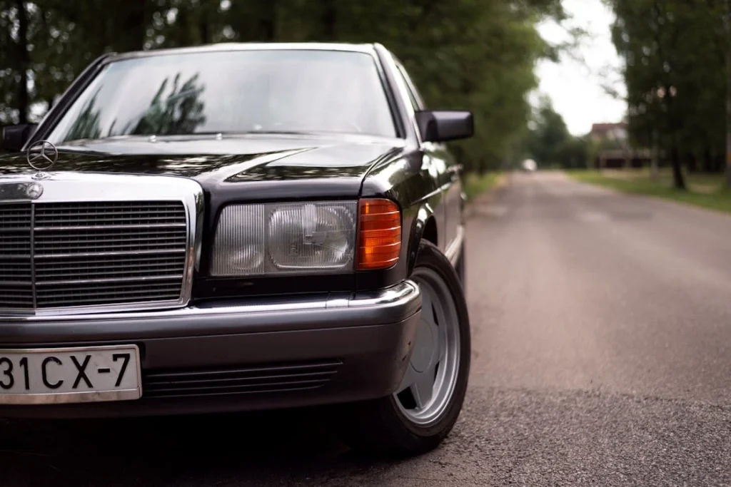 Vintage black Mercedes W126 on a road